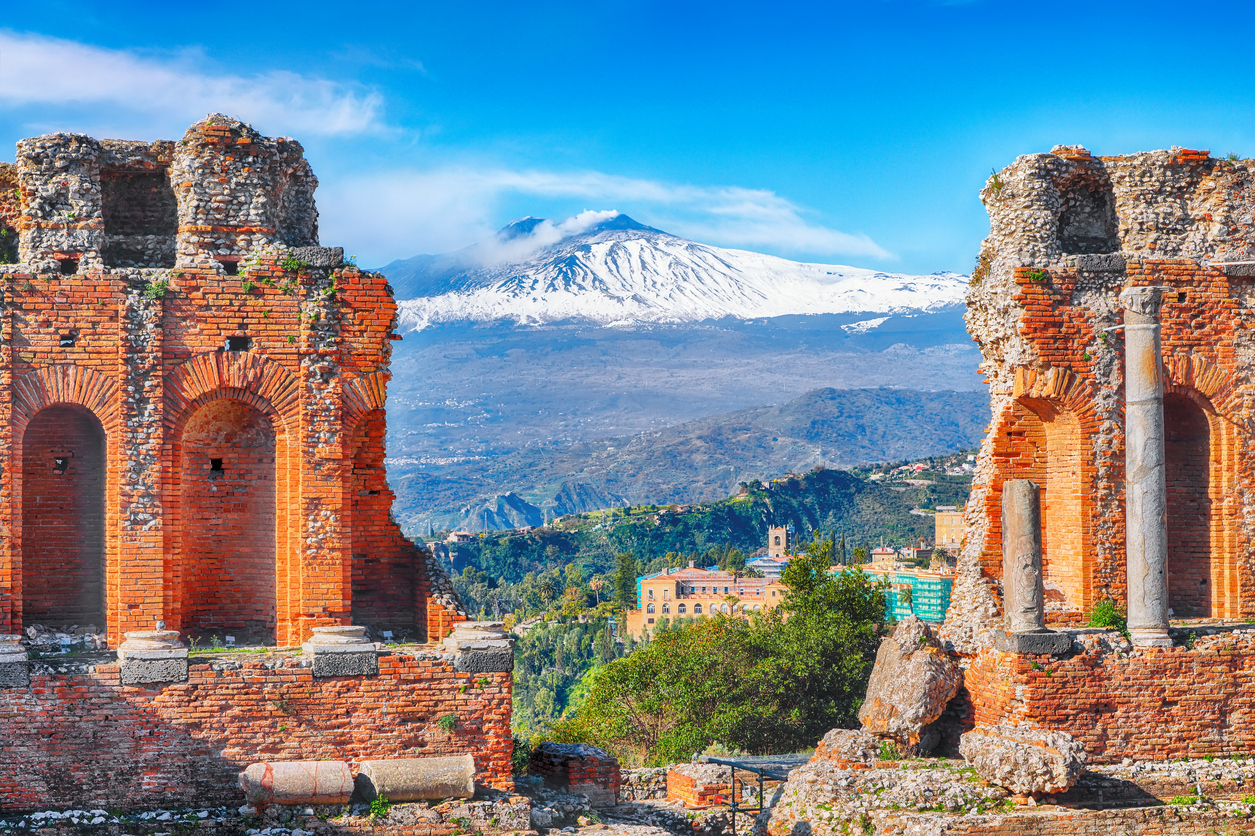 Taormina : ruines du théâtre grec antique et le volcan Etna en arrière-plan. © iStock / Pilat666